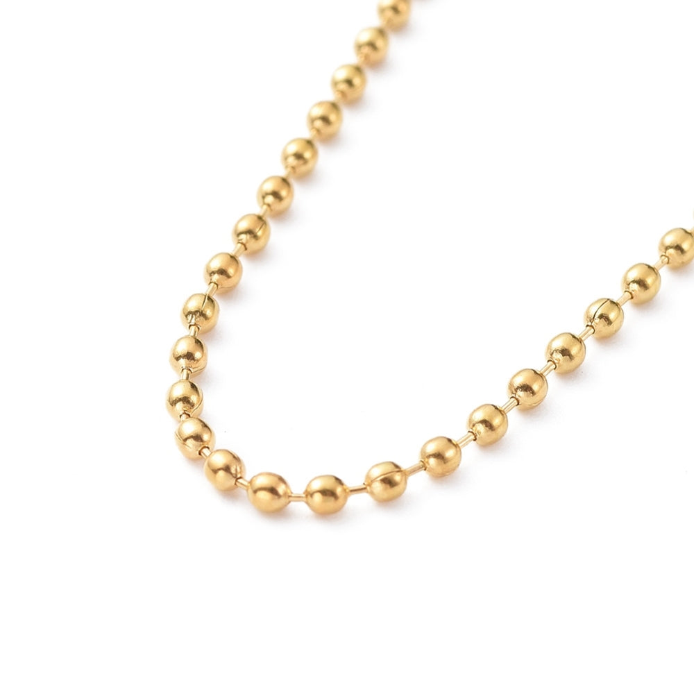 zoomed in section of golden ball chain over white background. 