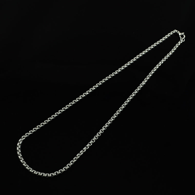 silver tone Venetian box chain necklace with lobster claw clasp over black background. 