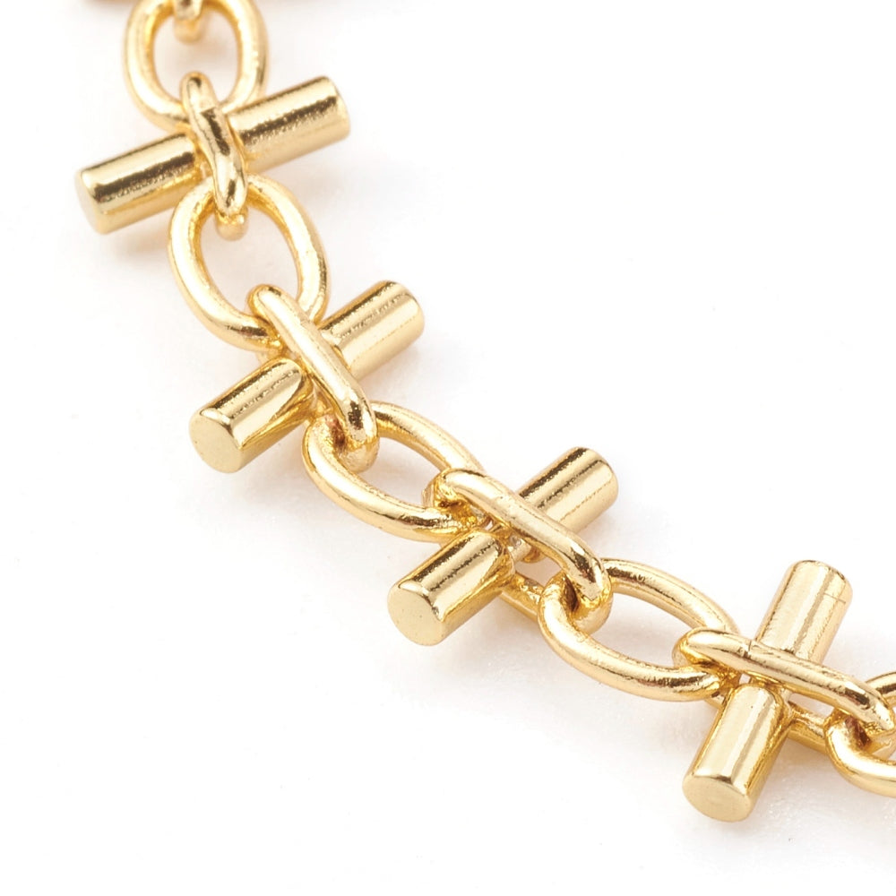 zoomed in section of golden bar link  bracelet on a white background.