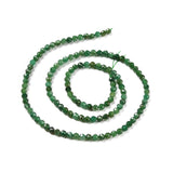 strand of dark green faceted round Fuchsite beads in a swirl design over white background. 