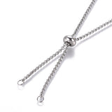 zoomed in portion of stainless steel, adjustable, rolo chain with slider stopper bead on a white background. 