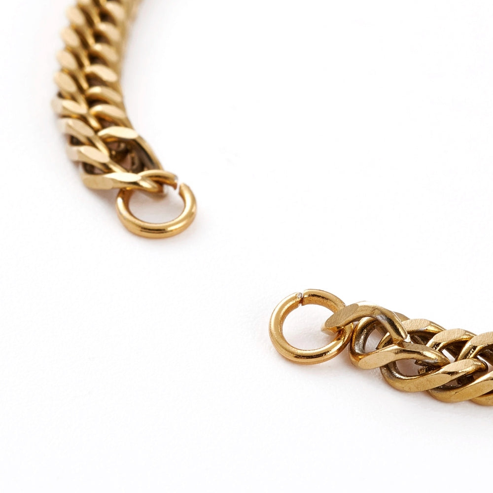golden diamond cut curb chain bracelet with 2 jump rings on a white background. 
