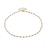 golden chain and black spinel faceted round beaded necklace with golden lobster claw clasp and extender chain over white background. 