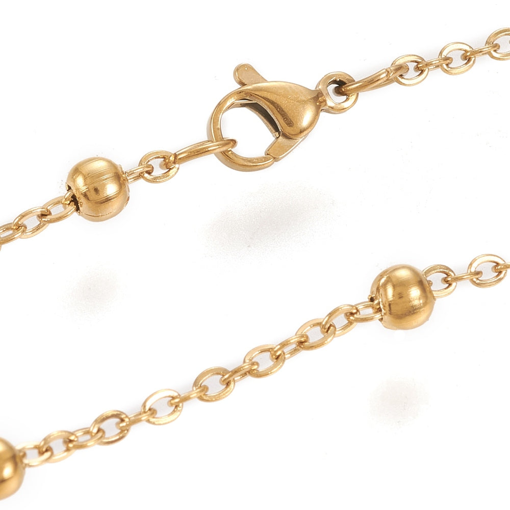 zoomed in sections of golden large bead satellite chain necklace with lobster claw clasp on white background. 