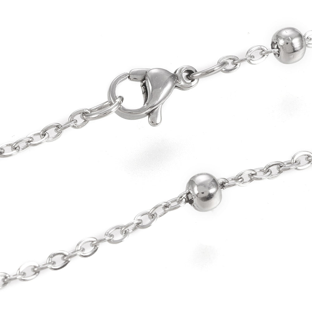 zoomed in sections of stainless steel large bead satellite chain necklace with lobster claw clasp on white background. 