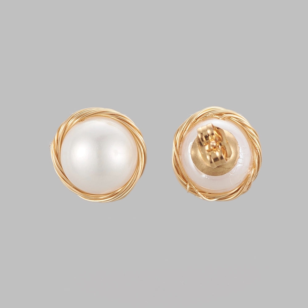 front and back of large white freshwater pearl stud earrings with golden wire wrapped "nest" surrounding pearl over grey background. 