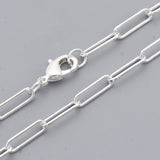 zoomed in sections of silver medium round oval paperclip chain necklace with lobster claw clasp on light gray background. 