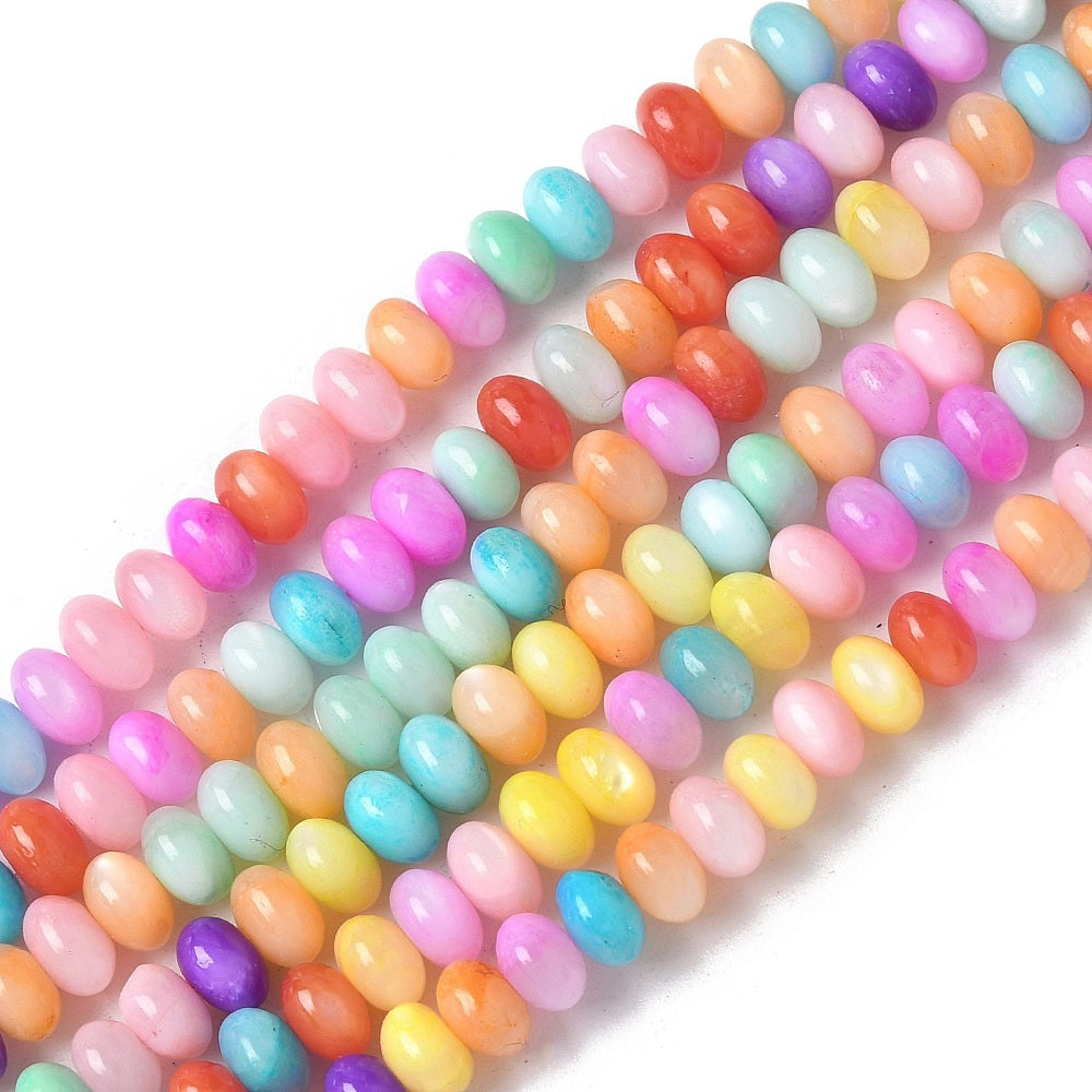 six strands of multicolor dyed shell rondelle beads on white background. 