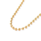 zoomed in portion of golden ball chain necklace on a white background. 