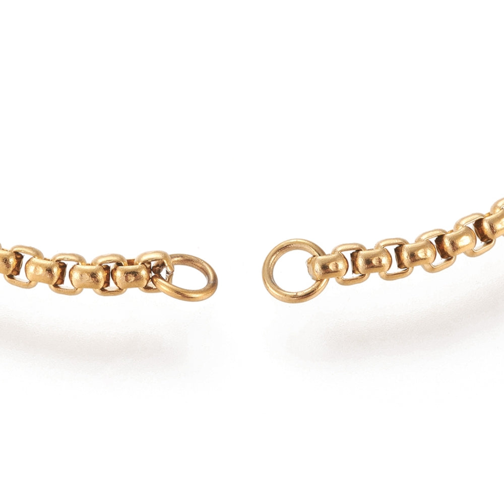 zoomed in golden jump rings on box chain ends on white background. 