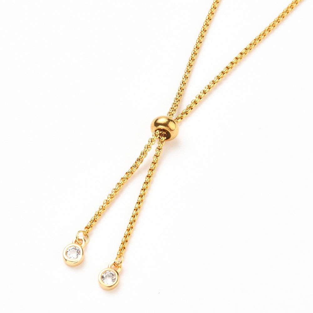 zoomed in section of the golden slider and bezel set clear stone stopper beads of the Bolo style bracelet makingon a white background 