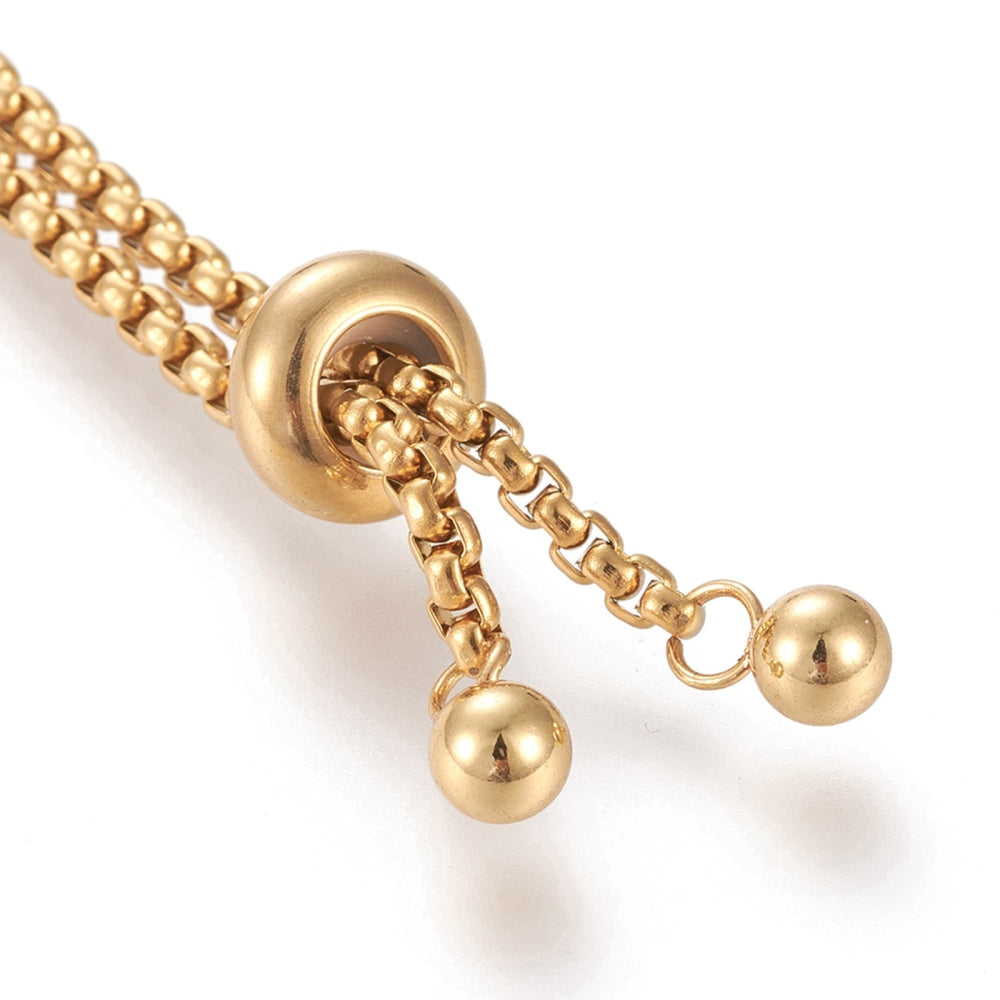 zoomed in golden slider bead and round stopper beads on box Bolo bracelet making with white background. 