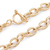 zoomed in sections of golden large cable chain necklace with toggle clasp on white background. 