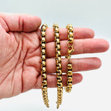golden Venetian chain bracelet with lobster claw clasp displayed on a hand on white background. 