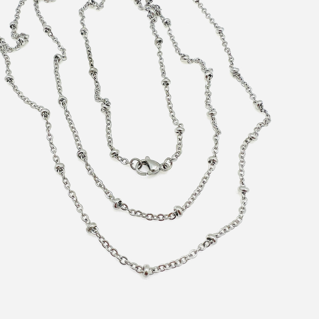 silver tone satellite cable chain necklace with lobster claw clasp over white background. 