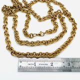 golden large Rolo chain necklace with lobster claw clasp above stainless steel imperial ruler on white background. 