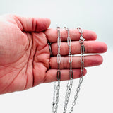 stainless steel medium link paperclip chain necklace with lobster claw clasp displayed on a hand with white background. 