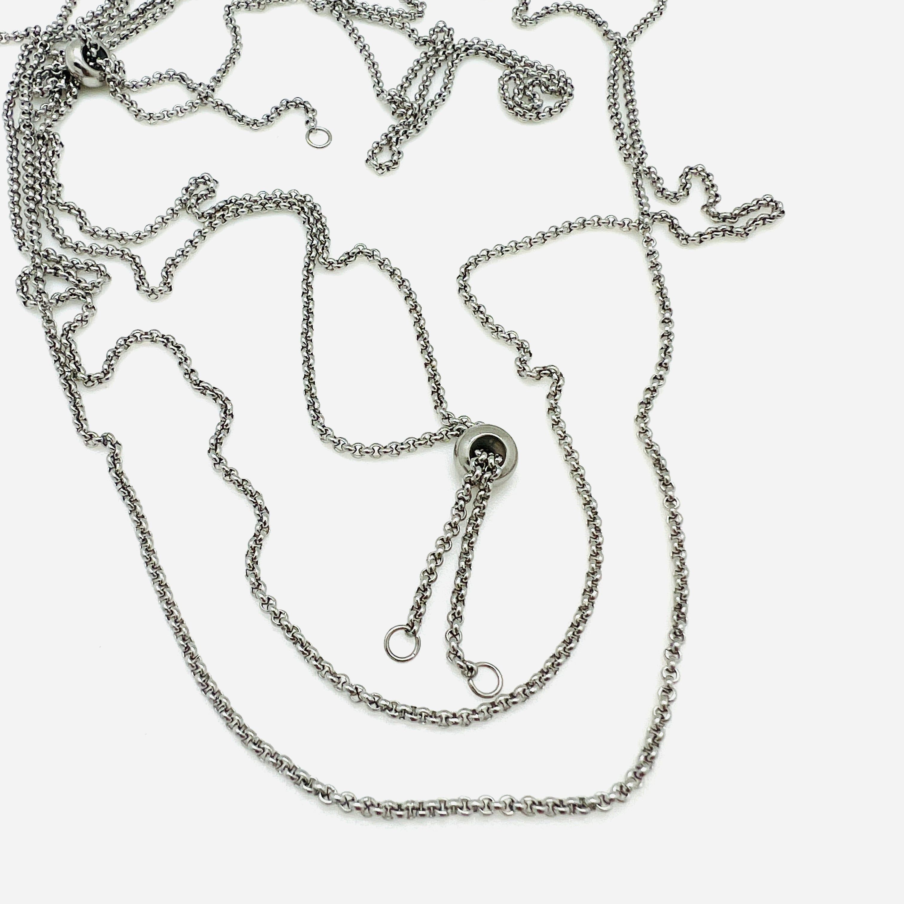 silver tone adjustable rolo chain with slider stopper bead on a white background. 