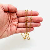 golden cable link double satellite chain necklace with lobster claw clasp displayed on a hand with a white background. 