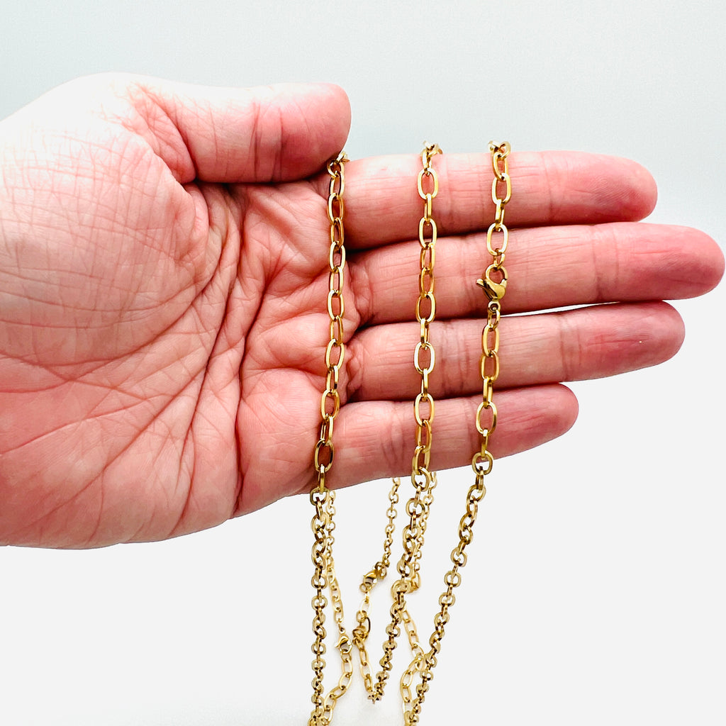 golden oval cable chain necklace with lobster claw clasp draped over a hand against a white background. 