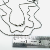 stainless steel rope chain with lobster claw clasp above a stainless steel imperial ruler  on white background. 