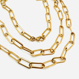 golden paperclip link chain necklace with lobster claw clasp on a white background. 