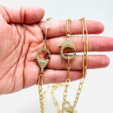 3 golden paperclip chain necklaces with focal clear stone pave lobster claw clasp displayed on a hand with white background. 