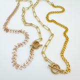golden mixed chain necklaces one with cob leaf and paperclip links and the other with curb chain and paperclip links on white background. 