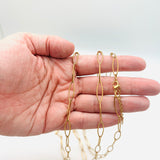 golden marquise paperclip chain necklace with lobster claw clasp and extender chain displayed on a hand on white background. 
