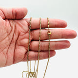 golden squared Rolo chain necklace with lobster claw clasp on a hand against a white background. 