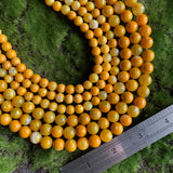 8mm yellow agate beads 10mm yellow agate beads on green background with ruler for scale