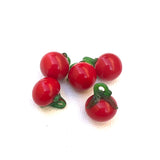 vintage red glass creole tomato charms on a white background