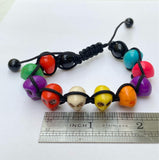 dyed multi-color stone skulls with black nylon cord as an adjustable bracelet with a ruler for scale