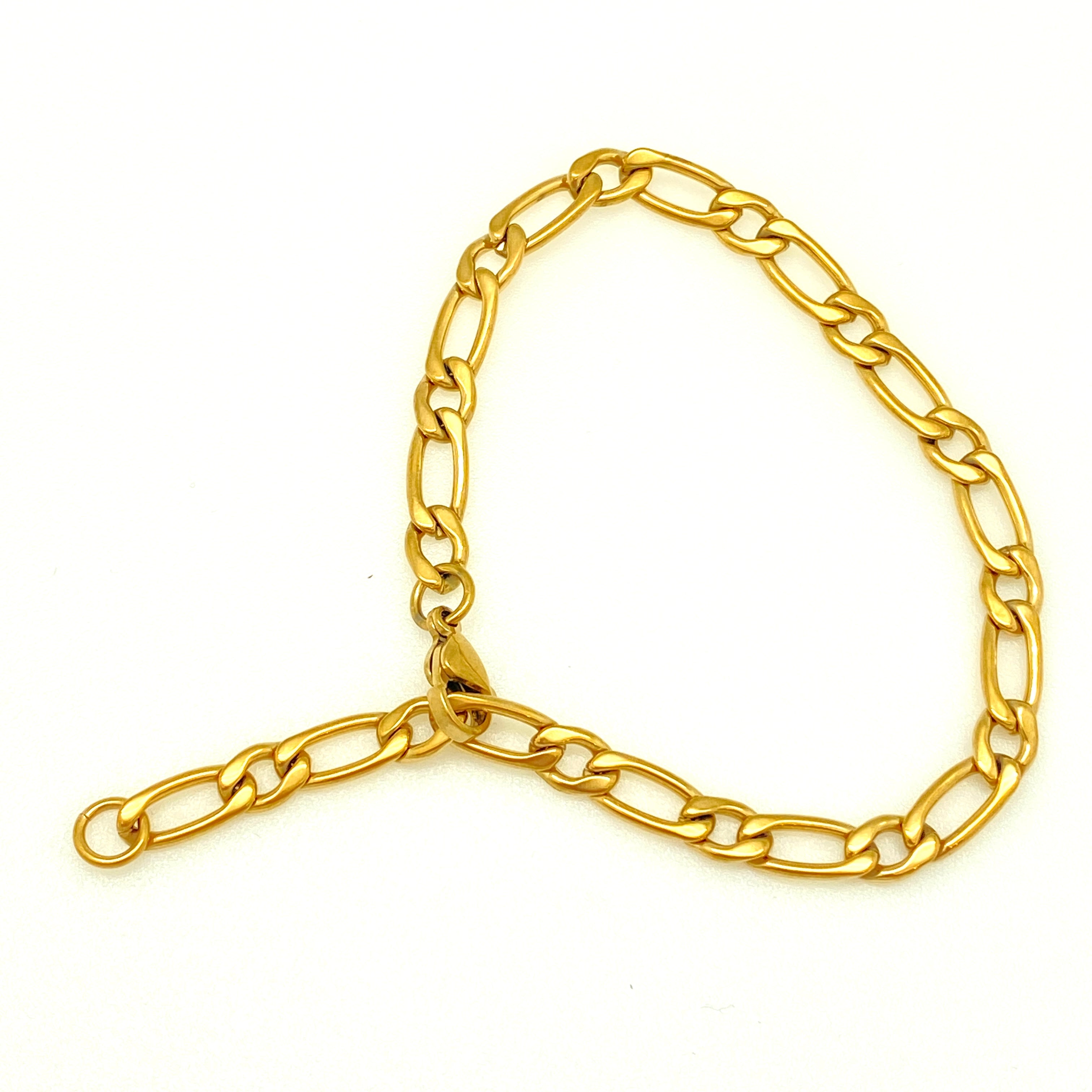 golden Figaro link bracelet with lobster claw clasp on white background. 