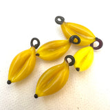 vintage yellow glass banana charms on a white background