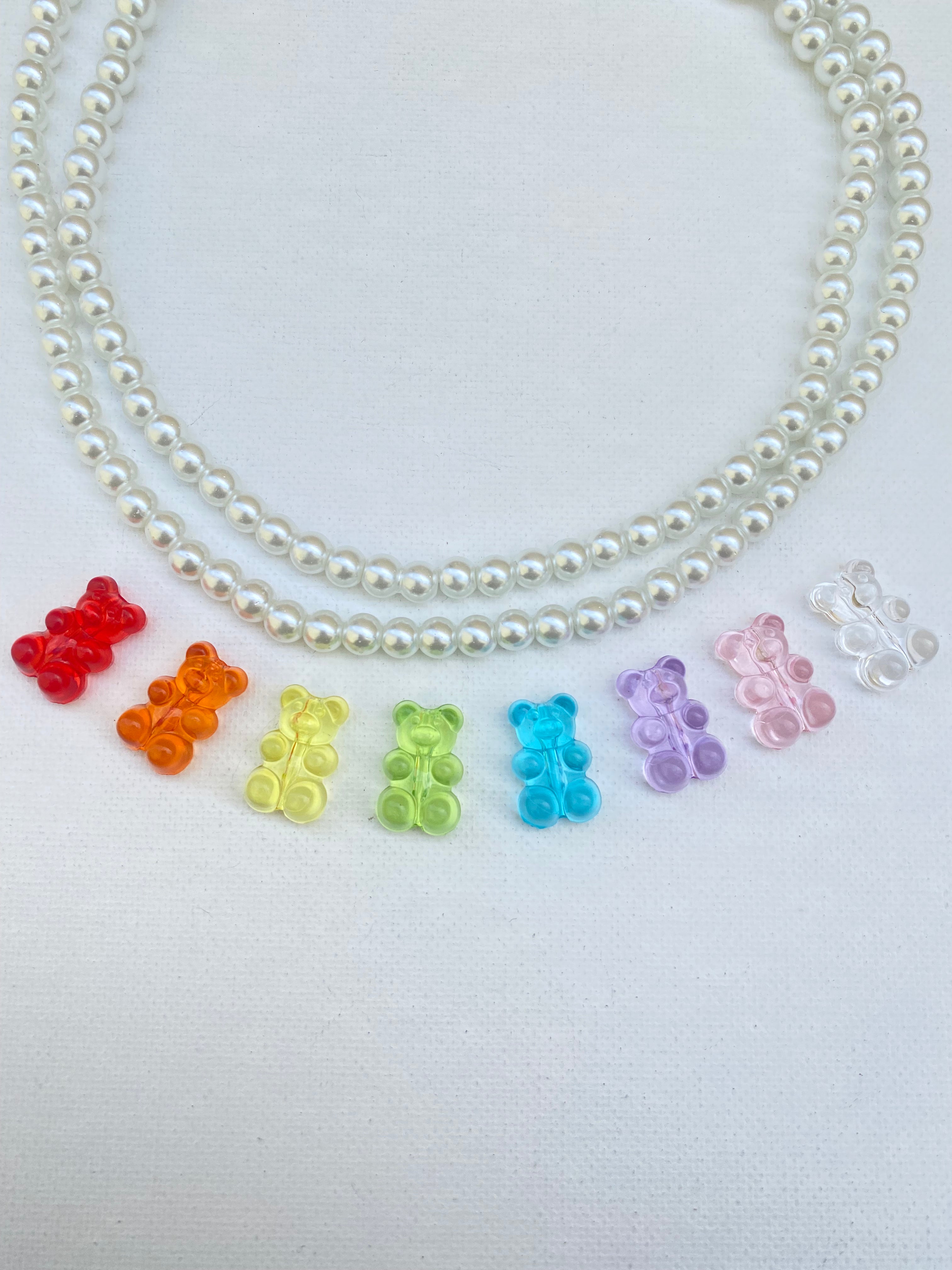 A photo of the strand of glass beads and the rainbow colored resin gummy bear beads, some of what you will get in the kit. 