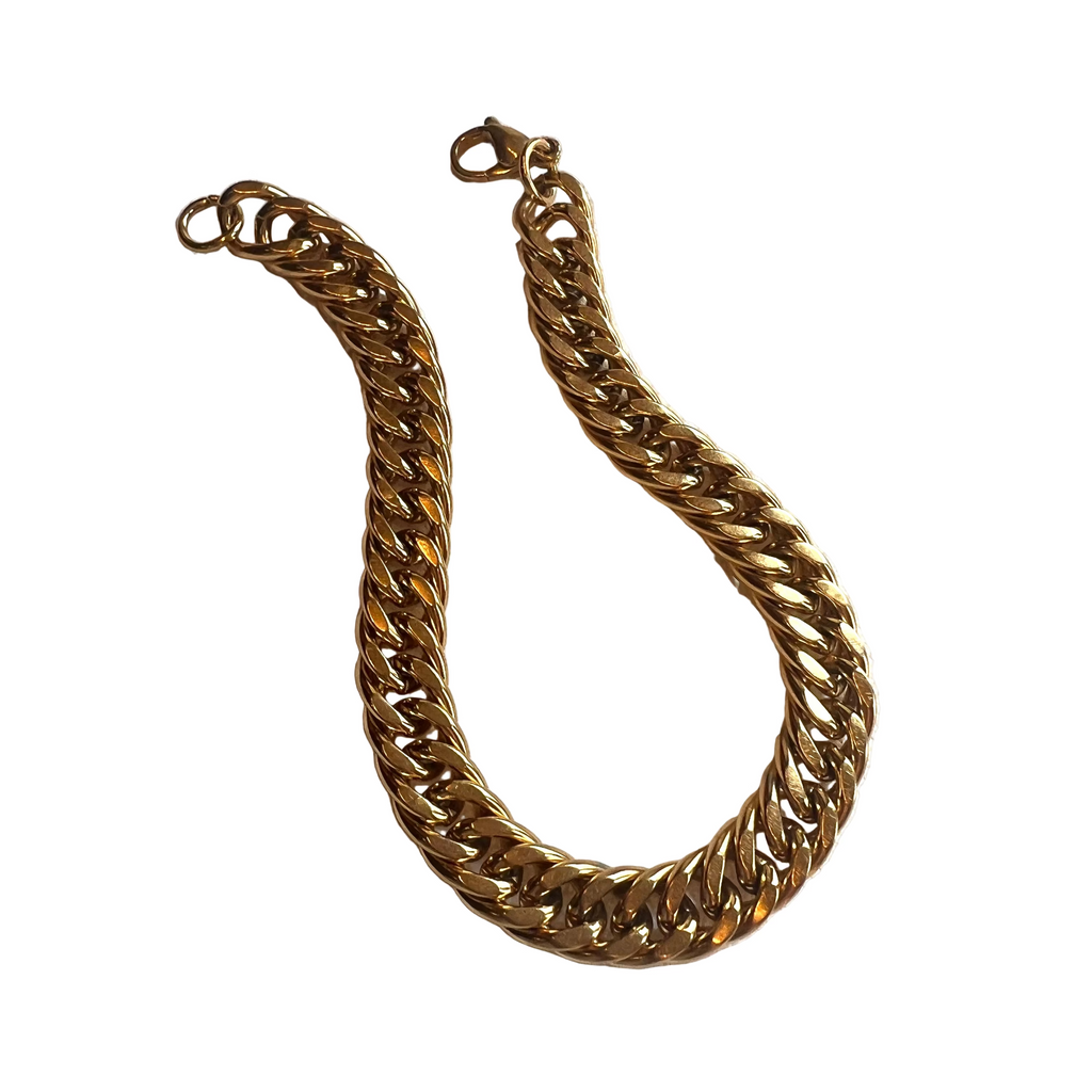heavy golden curb chain link bracelet with lobster claw clasp over white background. 
