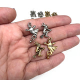 silver and gold pewter charms in a hand for scale. Charms are a gold witch on a broom, a gold ghost with the word "boo!", a silver witch on a broom and a silver ghost with the word "Boo!" on a white background