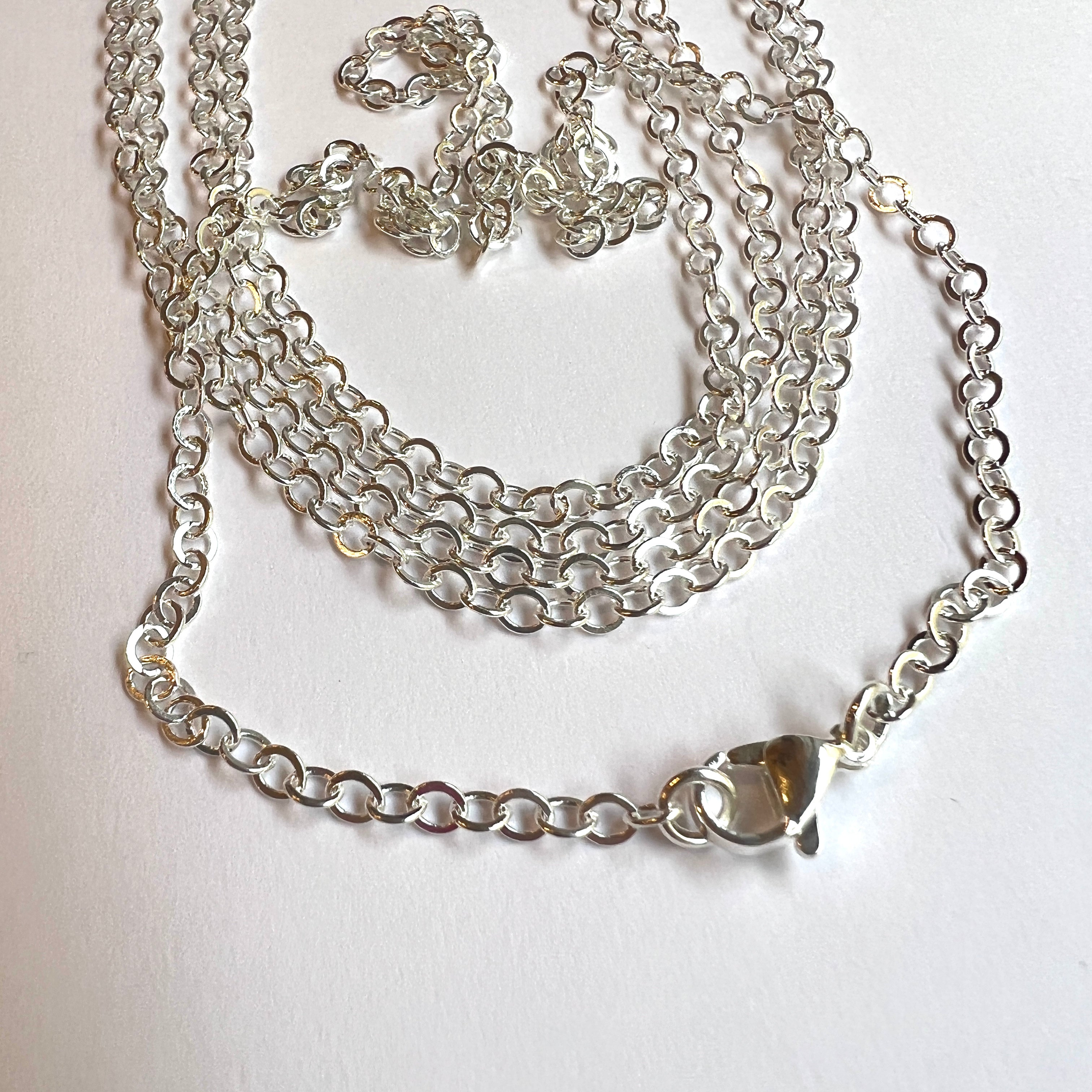 silver tone cable chain necklace with lobster claw over white background. 