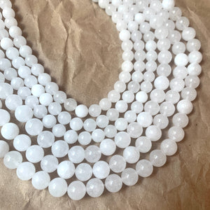 8mm and 10mm translucent natural white jade beads on a brown paper background