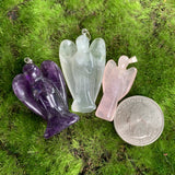 carved amethyst angel pendant, carved fluorite angel pendant, carved rose quartz angel pendant on green background with US quarter for scale