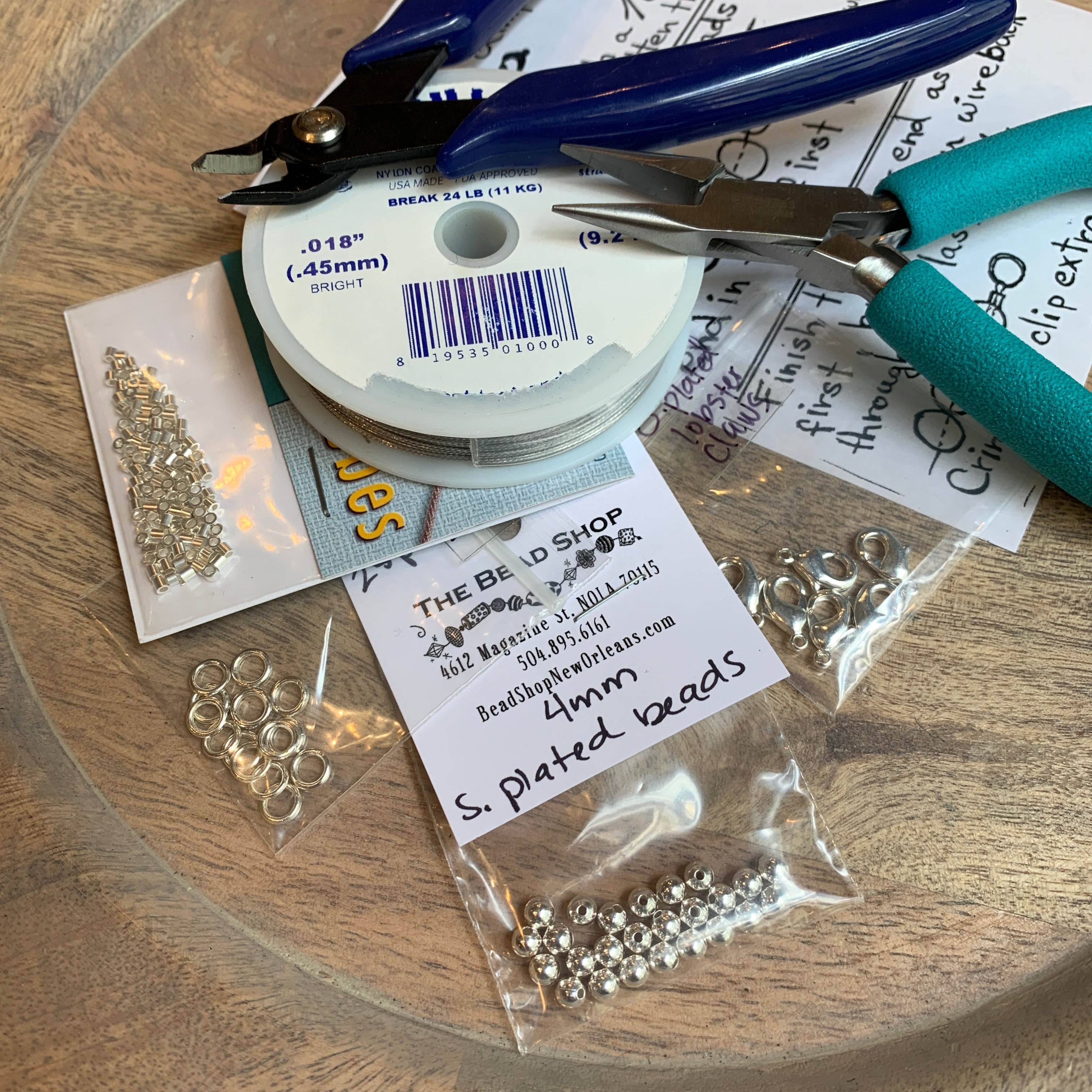 basic beading tool kit full of jewelry making supplies including chain nose pliers, soft wire cutters, beading wire, crimp beads, soldered rings, lobster claw clasps and 4mm round beads