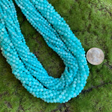 3mm faceted round blue Amazonite bead strands 4mm faceted round blue Amazonite bead strands on green background with US quarter for scale
