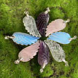 carved amethyst wing pendant, carved rose quartz wing pendant, carved opalite wing pendant, carved quartz wing pendant on green background